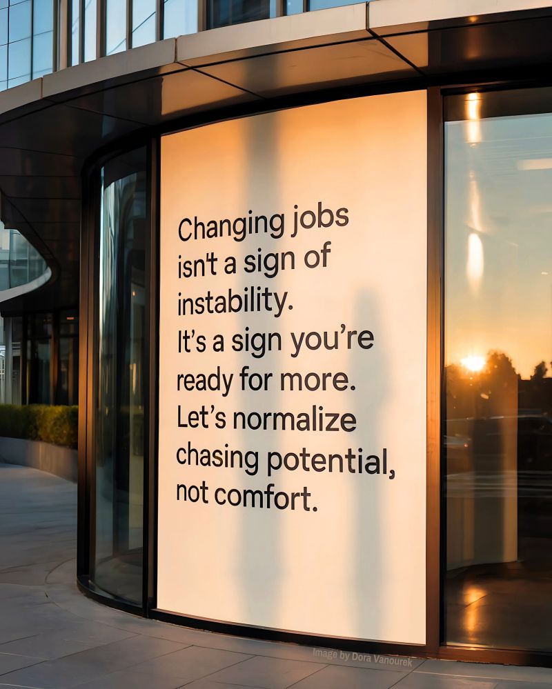 Modern office building with inspirational quote about changing jobs and chasing potential over comfort